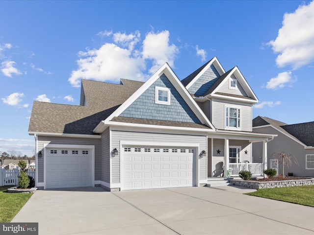 view of front of property with driveway, a porch, an attached garage, and a shingled roof