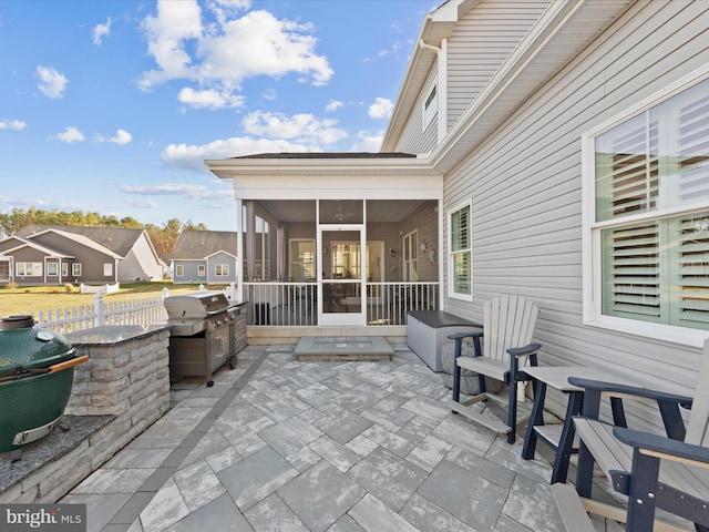 view of patio / terrace with a grill, fence, and a sunroom