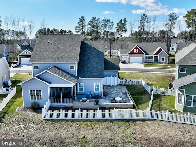 back of house featuring a patio, roof with shingles, a yard, a fenced backyard, and a residential view