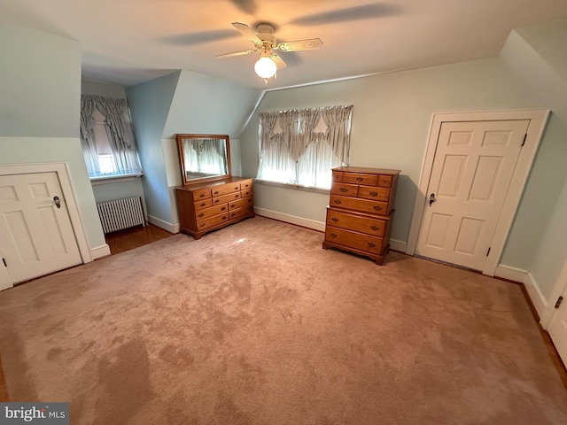 bonus room featuring baseboards, radiator, ceiling fan, vaulted ceiling, and carpet flooring