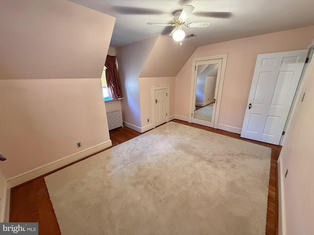 additional living space featuring lofted ceiling, baseboards, ceiling fan, and radiator heating unit