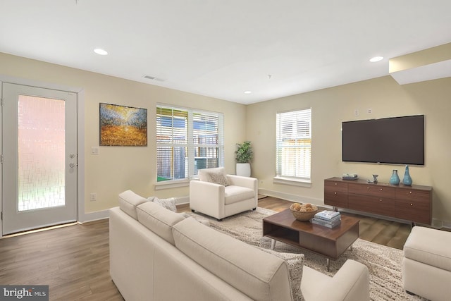 living room featuring recessed lighting, visible vents, baseboards, and wood finished floors