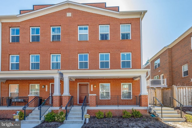 multi unit property with brick siding and a porch