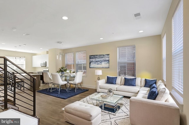 living area with recessed lighting, wood finished floors, visible vents, and baseboards