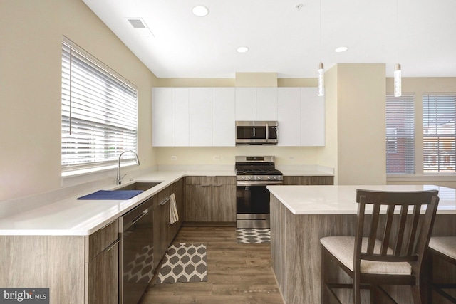 kitchen featuring visible vents, light countertops, stainless steel appliances, dark wood-style floors, and white cabinetry