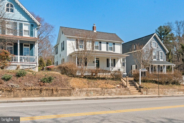 view of front of house featuring covered porch and a chimney