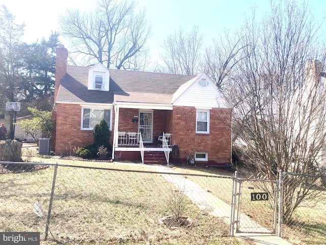 view of front of property with brick siding, a fenced front yard, and a porch