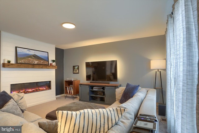 living area featuring carpet floors and a glass covered fireplace