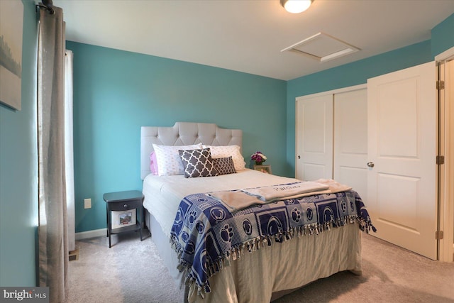 bedroom with light carpet, a closet, attic access, and baseboards