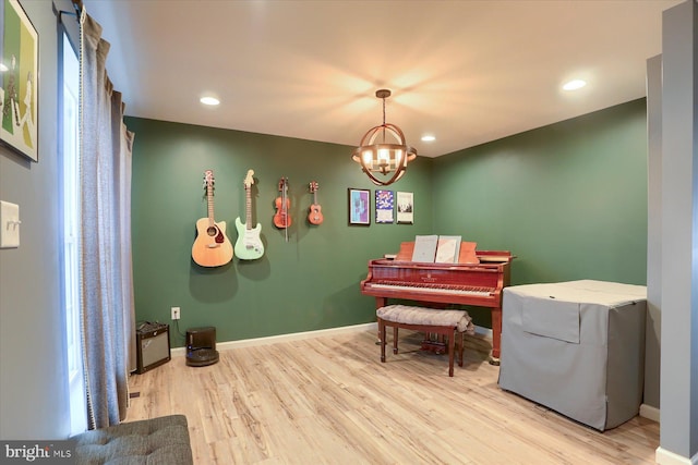 living area with an inviting chandelier, baseboards, and wood finished floors