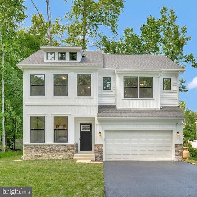 view of front of home featuring stone siding, a shingled roof, aphalt driveway, and a front yard