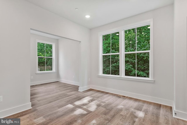 spare room with recessed lighting, wood finished floors, visible vents, and baseboards