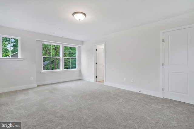 empty room featuring carpet and baseboards