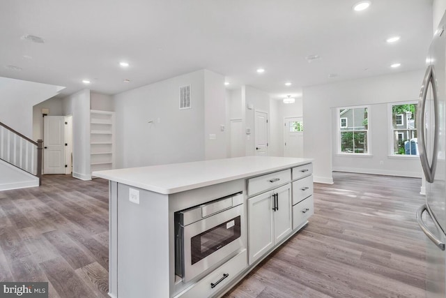 kitchen featuring visible vents, light wood-style flooring, a kitchen island, stainless steel appliances, and recessed lighting