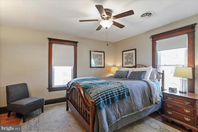 bedroom with visible vents, ceiling fan, baseboards, and wood finished floors