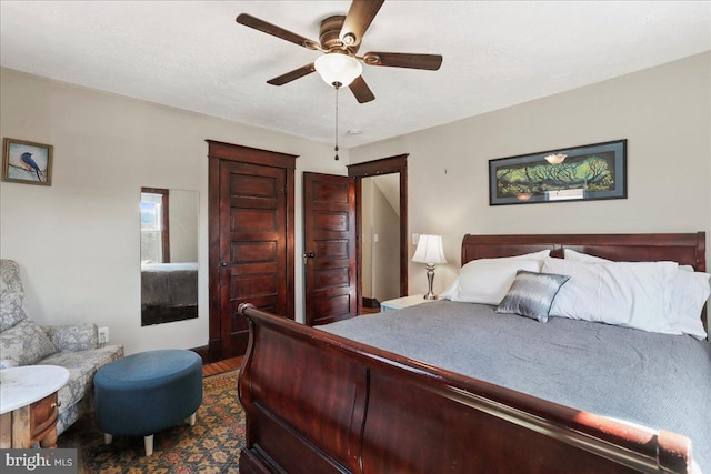 bedroom featuring ceiling fan, dark wood finished floors, and a textured ceiling