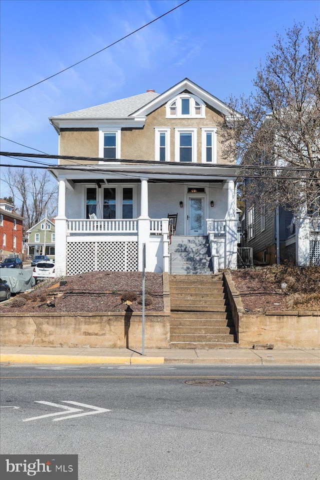 view of front facade with covered porch and stucco siding