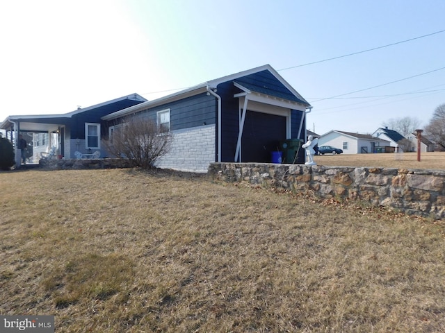 view of side of property with a lawn and an attached garage