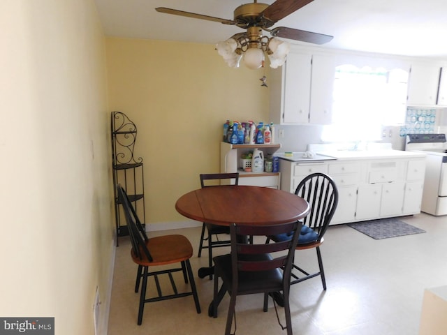 dining room featuring baseboards, ceiling fan, and light floors