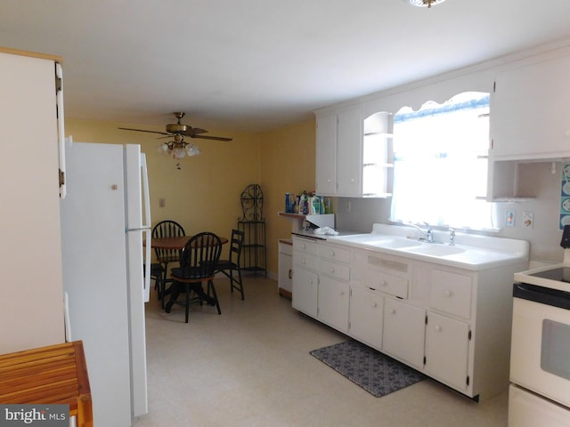 kitchen featuring white appliances, a sink, and white cabinetry