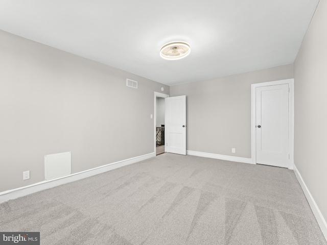 carpeted empty room featuring visible vents and baseboards