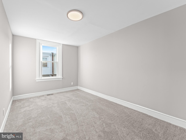 unfurnished room featuring carpet floors, visible vents, and baseboards