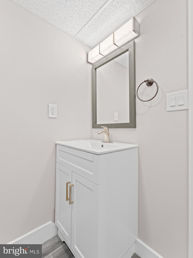 bathroom with vanity, baseboards, and wood finished floors