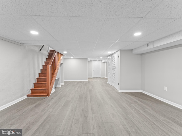 finished below grade area with stairs, recessed lighting, wood finished floors, and baseboards