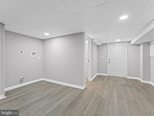 finished below grade area featuring a paneled ceiling, baseboards, wood finished floors, and recessed lighting