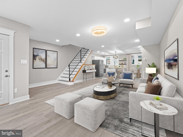 living room featuring baseboards, stairway, wood finished floors, and recessed lighting