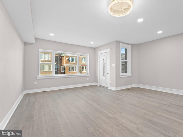 unfurnished living room featuring baseboards, wood finished floors, and recessed lighting