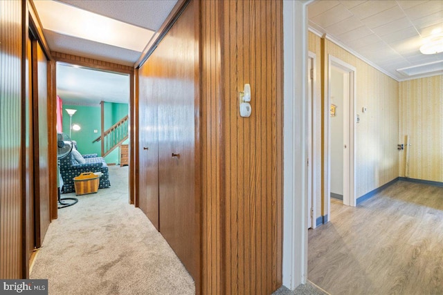 hallway with baseboards, crown molding, and wood finished floors