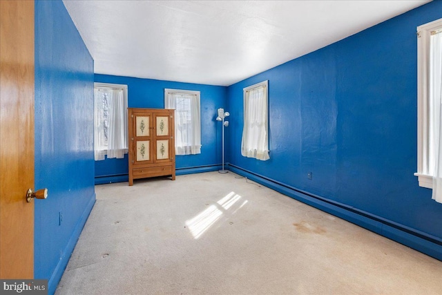 carpeted empty room featuring baseboards