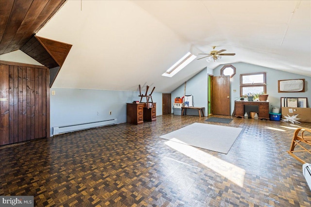 bonus room featuring a ceiling fan, a baseboard radiator, vaulted ceiling with skylight, and baseboard heating