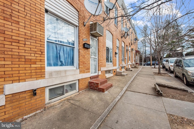 exterior space with entry steps and brick siding