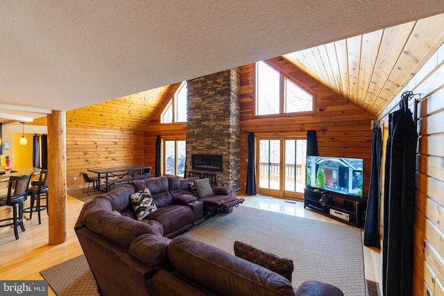 living room with wooden ceiling, wooden walls, and light wood-style floors