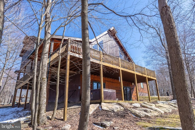 exterior space with log veneer siding and a deck