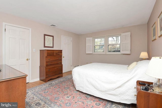 bedroom featuring visible vents and wood finished floors