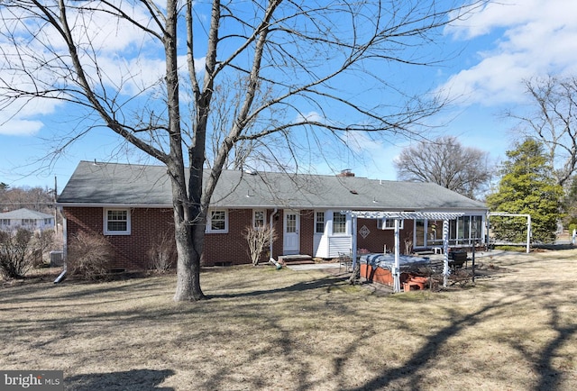 ranch-style house featuring brick siding, a hot tub, a chimney, crawl space, and a pergola