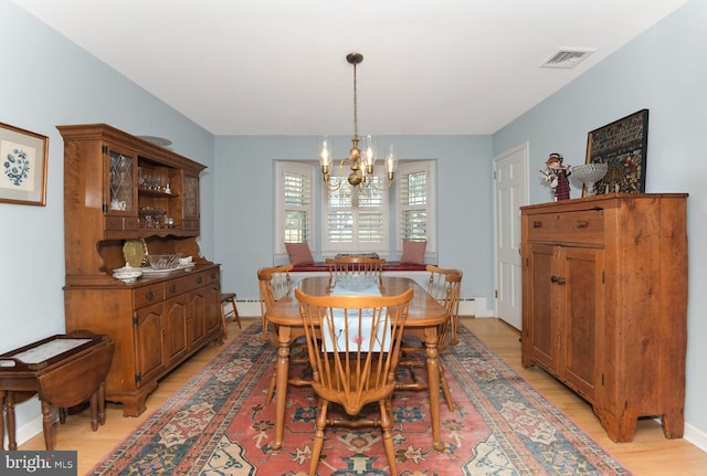 dining room with light wood-type flooring, visible vents, a notable chandelier, a baseboard radiator, and baseboards