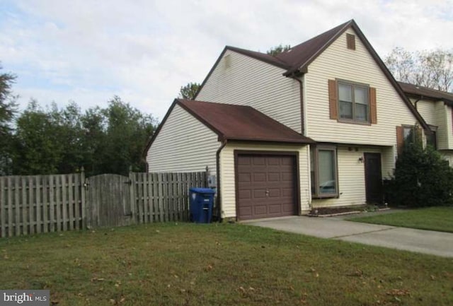 view of side of home featuring an attached garage, fence, driveway, a lawn, and a gate