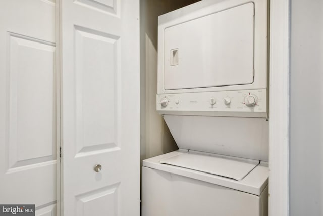 clothes washing area with stacked washer / drying machine and laundry area