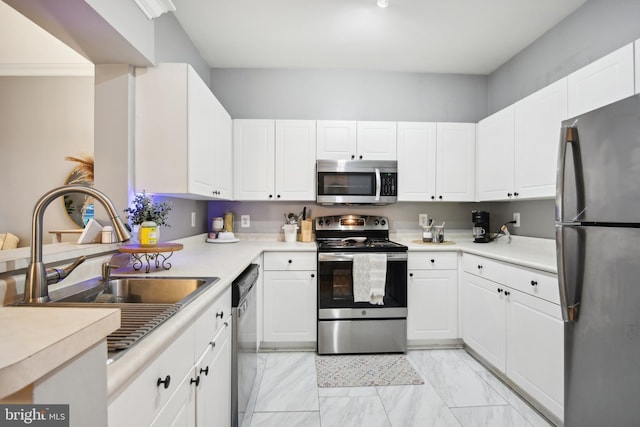 kitchen featuring marble finish floor, a sink, stainless steel appliances, white cabinets, and light countertops