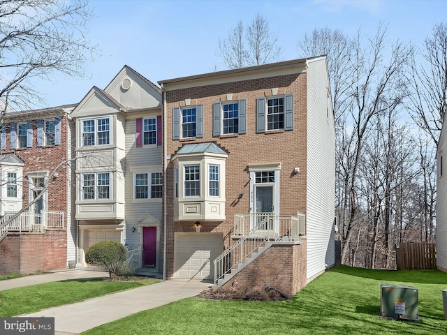 view of property featuring a front yard, brick siding, driveway, and an attached garage