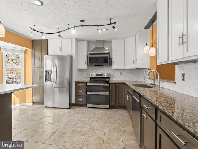 kitchen with appliances with stainless steel finishes, stone countertops, white cabinetry, and a sink