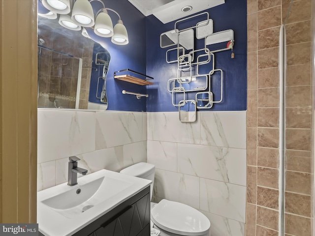 bathroom featuring tile walls, toilet, and vanity