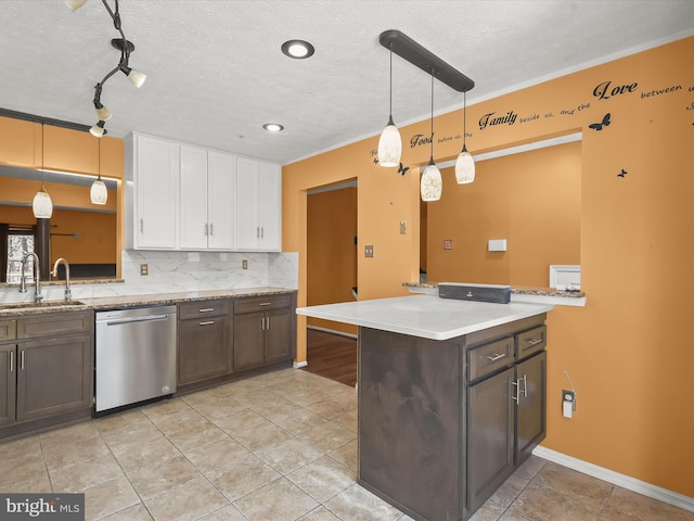 kitchen with a sink, white cabinets, dark brown cabinets, stainless steel dishwasher, and decorative backsplash