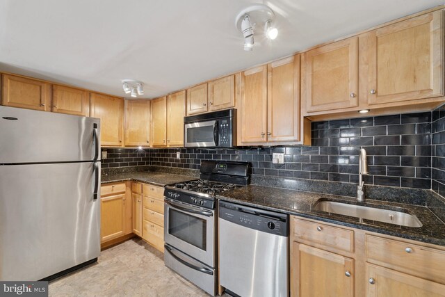 1029 Spruce St Unit 304, Philadelphia, PA 19107 - kitchen featuring light brown cabinetry, dark stone counters, a sink, appliances with stainless steel finishes, and backsplash