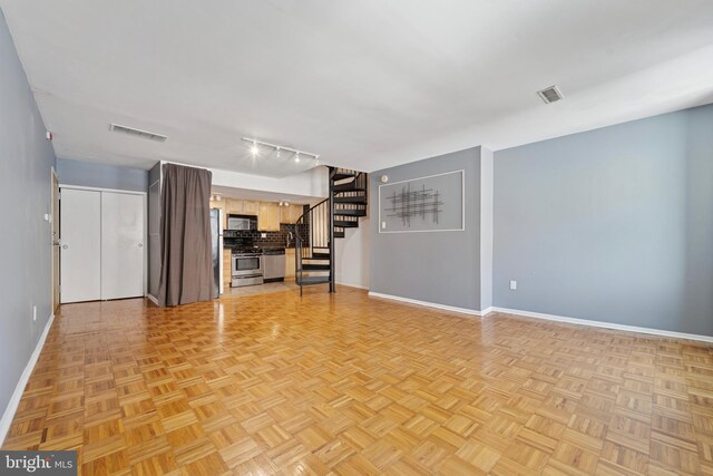 1029 Spruce St Unit 304, Philadelphia, PA 19107 - unfurnished living room featuring visible vents, baseboards, and stairs