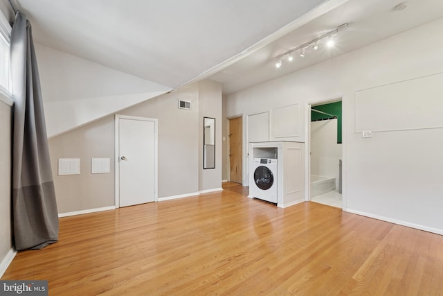 1029 Spruce St Unit 304, Philadelphia, PA 19107 - unfurnished living room featuring light wood finished floors, rail lighting, baseboards, washer / dryer, and visible vents